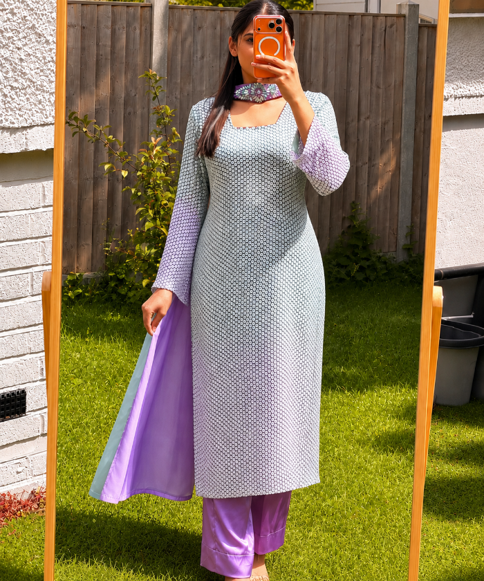 Woman wearing mint green sequin Pakistani suit with lavender trousers and pastel dupatta in elegant festive ethnic style.