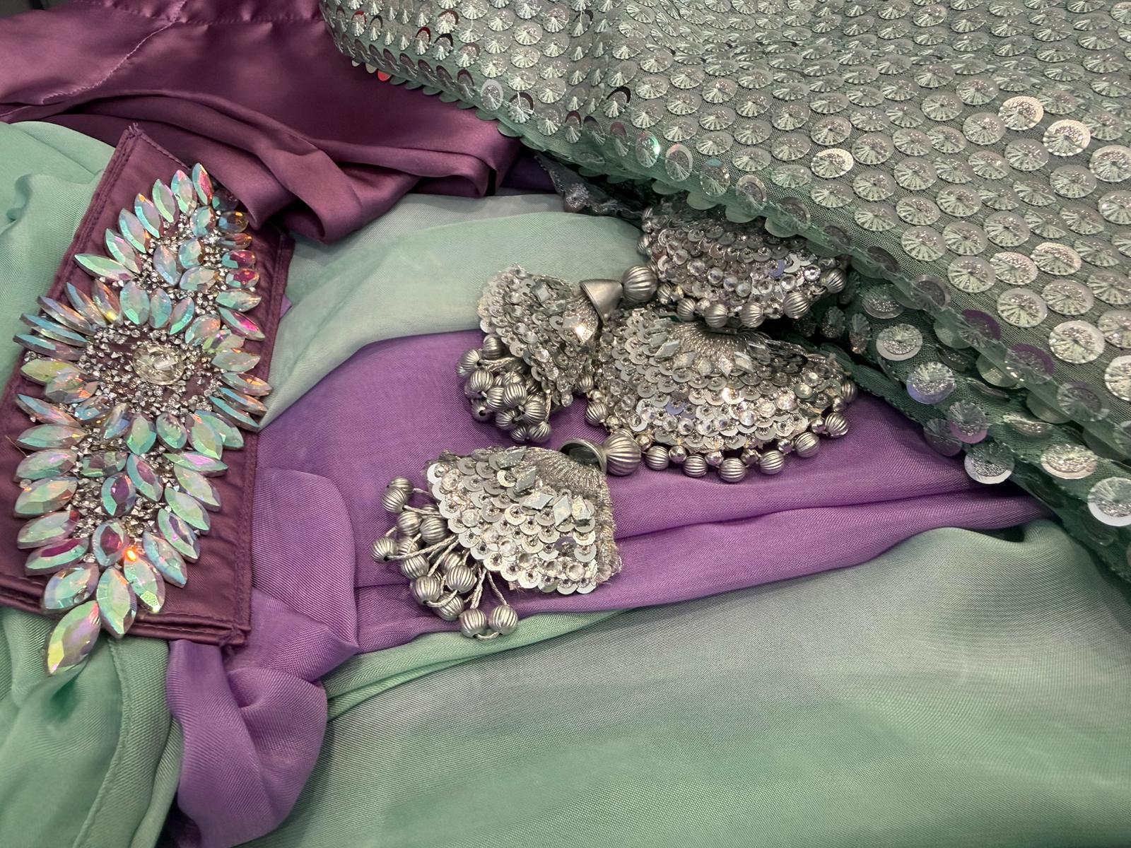 Woman wearing mint green sequin Pakistani suit with lavender trousers and pastel dupatta in elegant festive ethnic style.